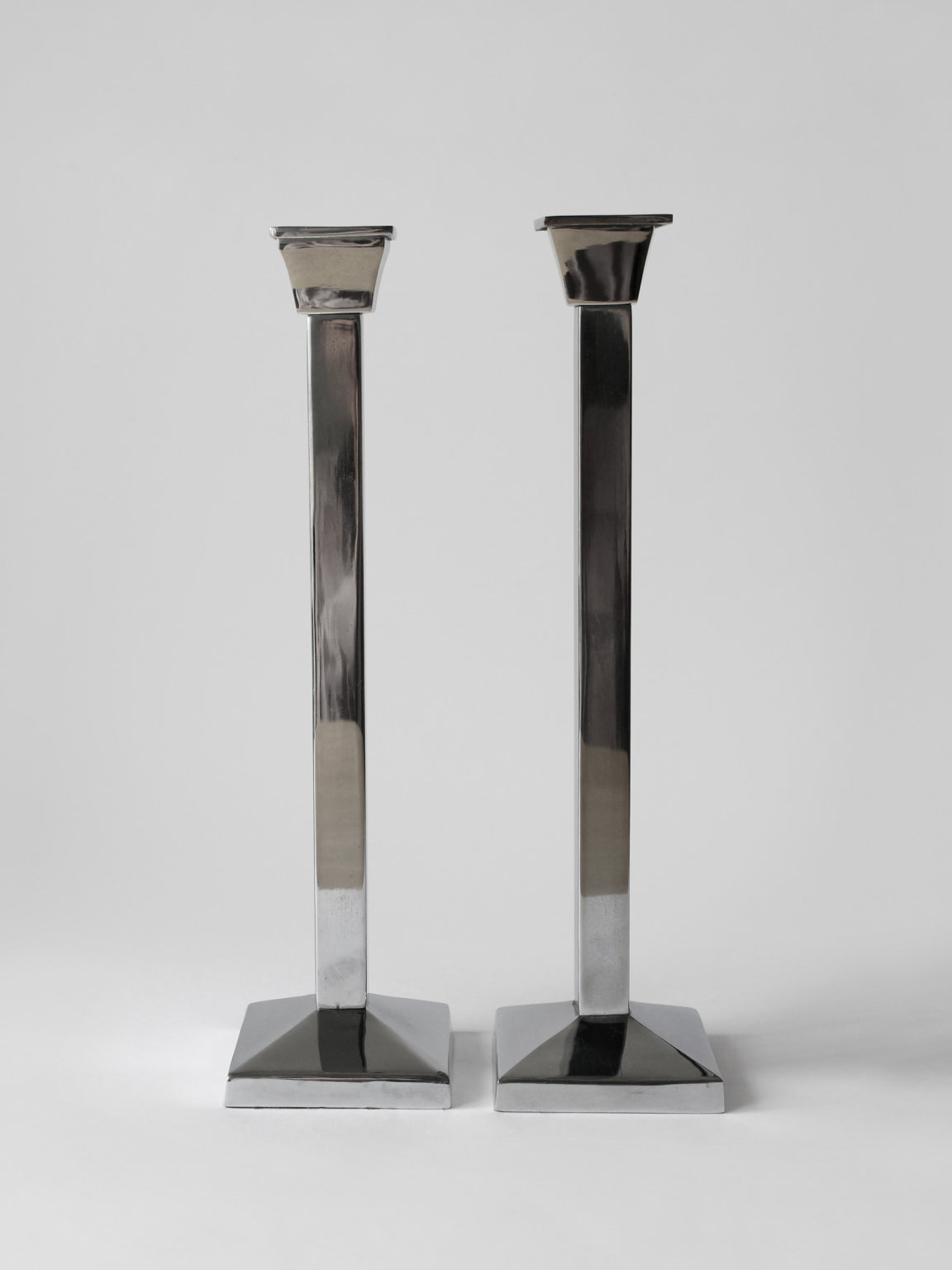 Pair Of Polished Mirror Metal Tall Candle Holders by Vintage Stories | The Oblist — polished metal finish, modern design