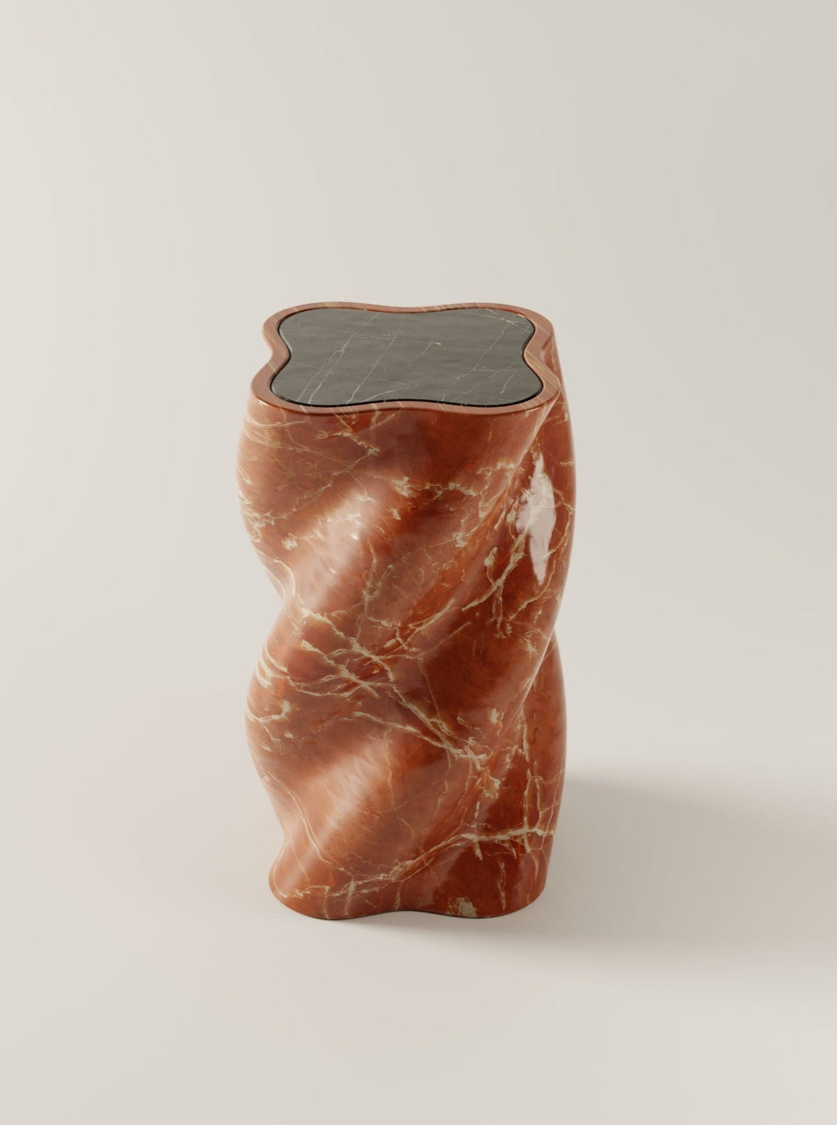 Sculptural red marble end table with organic twisted form