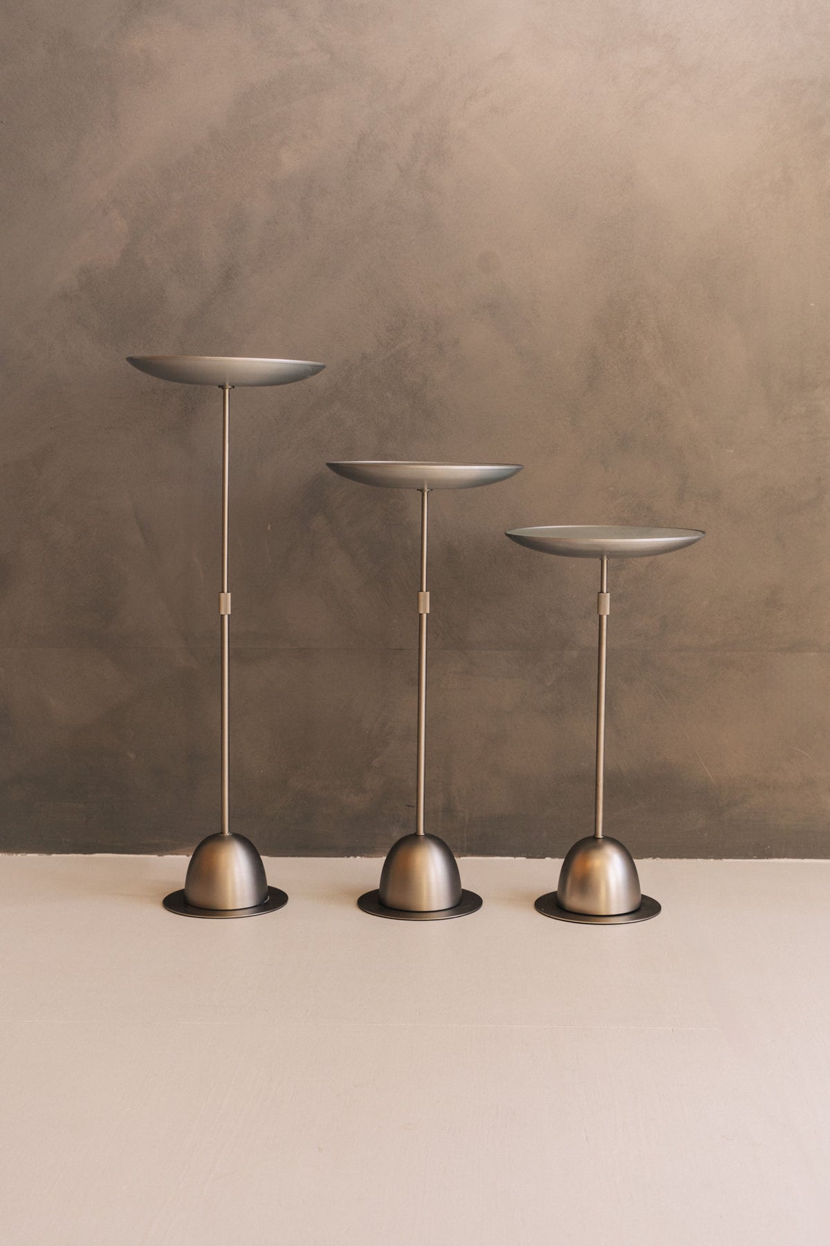 Three bronze adjustable side tables with dome bases by David Quan