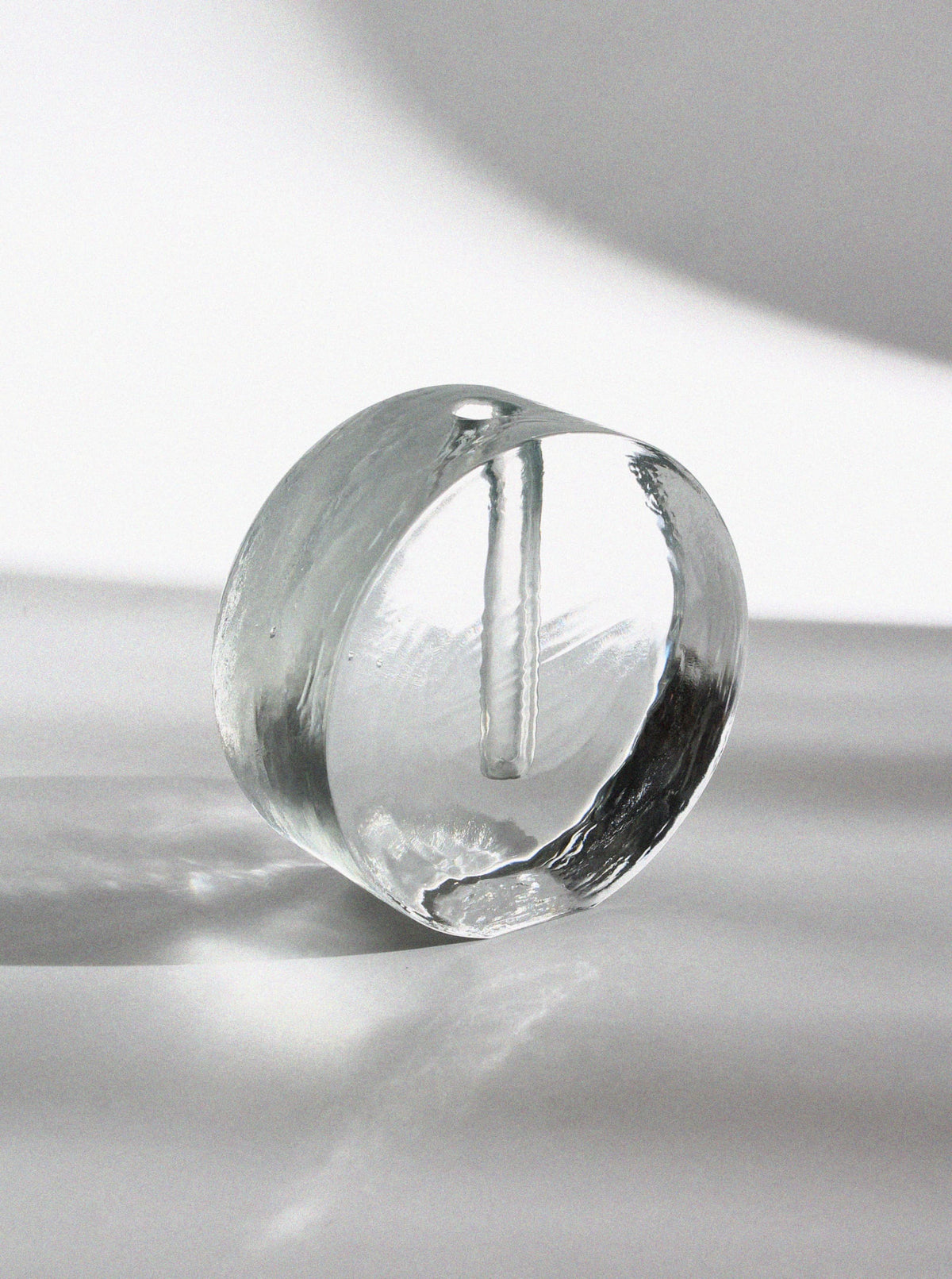 Clear glass round block vase with central opening for single stem