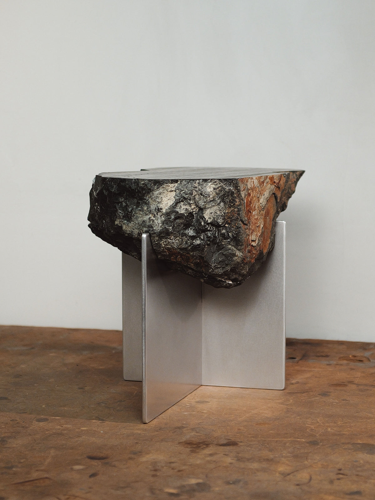 Large stone slab side table on metal stand by Estudio Material