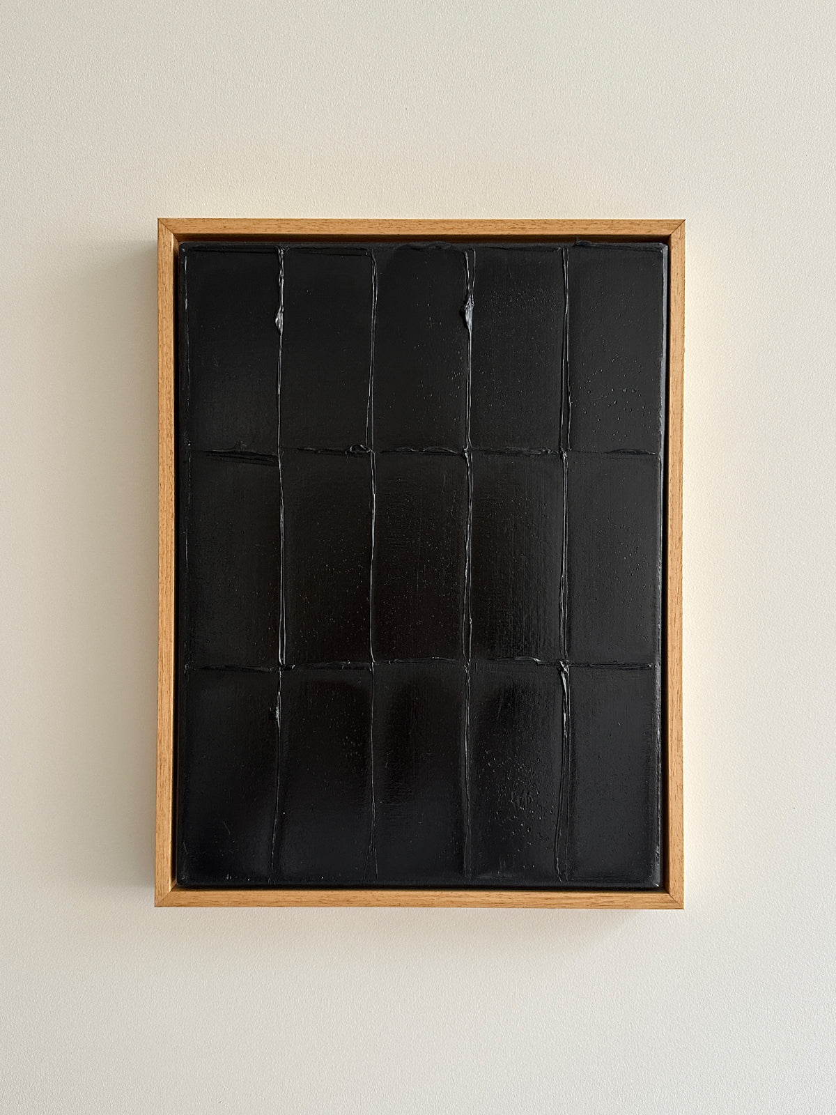 Abstract black paint grid artwork in natural wood frame by Roi Elmaliah