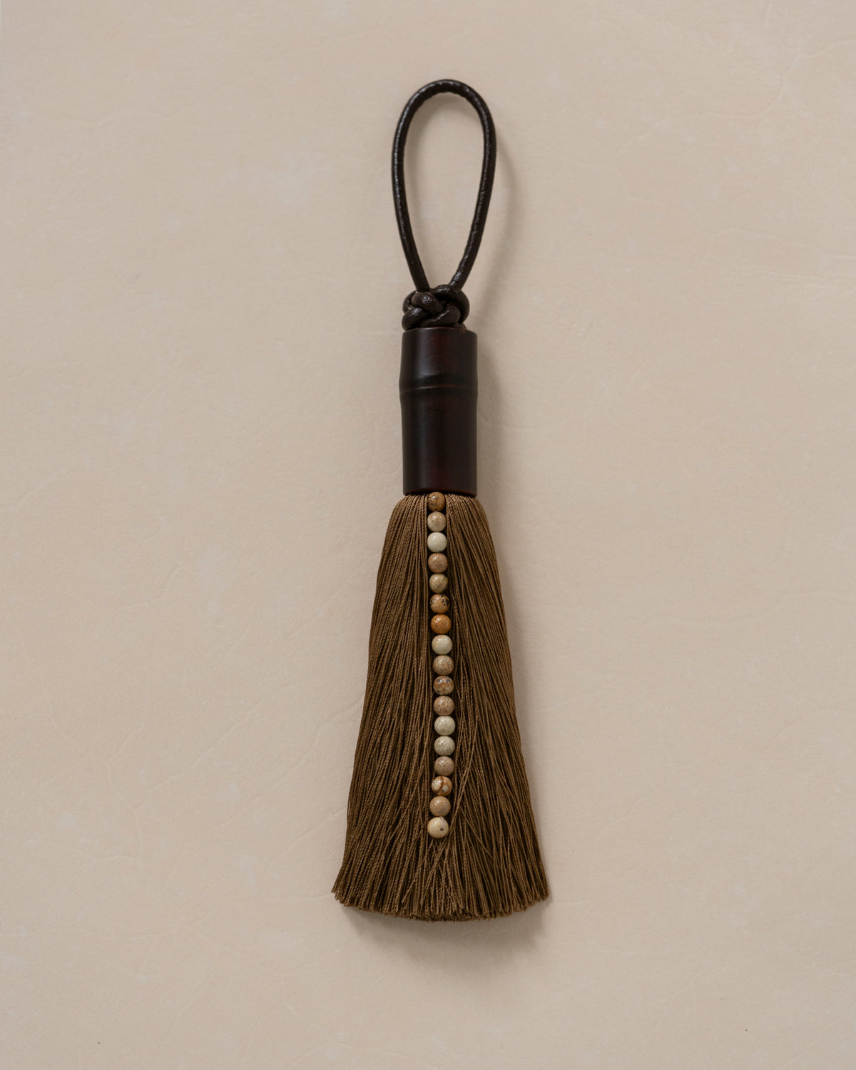 Brown tassel ornament with wooden beads and black leather loop