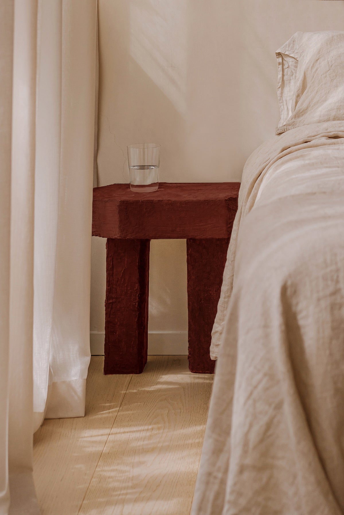 Red clay Ruins side table by Szymon Keller in bedroom setting