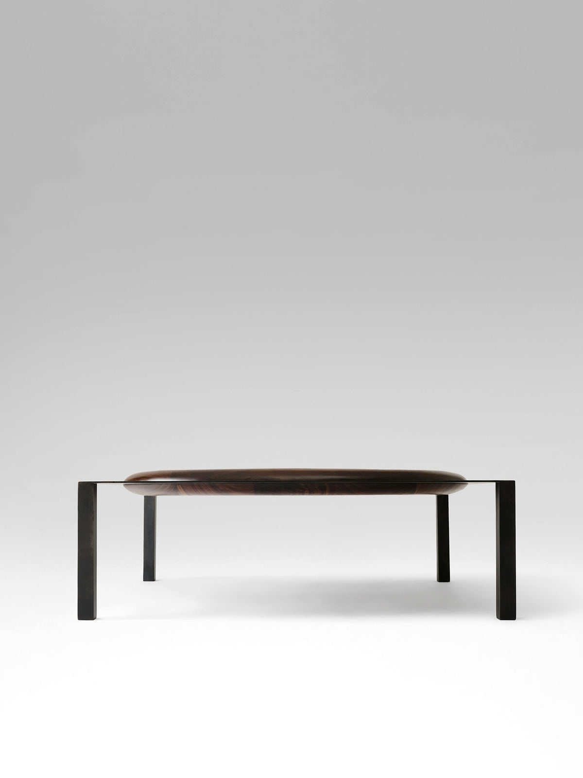 Split coffee table with dark wood oval top and black metal legs