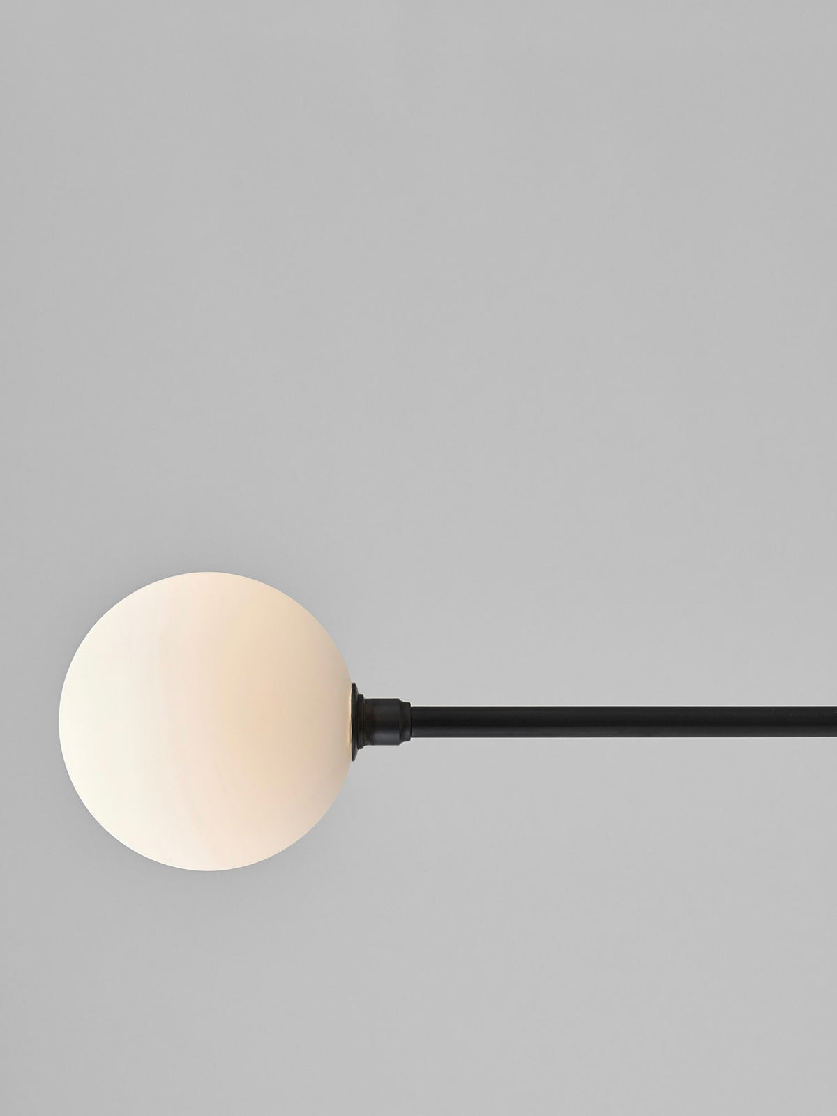 Modern floor lamp with cream spherical shade and black metal arm