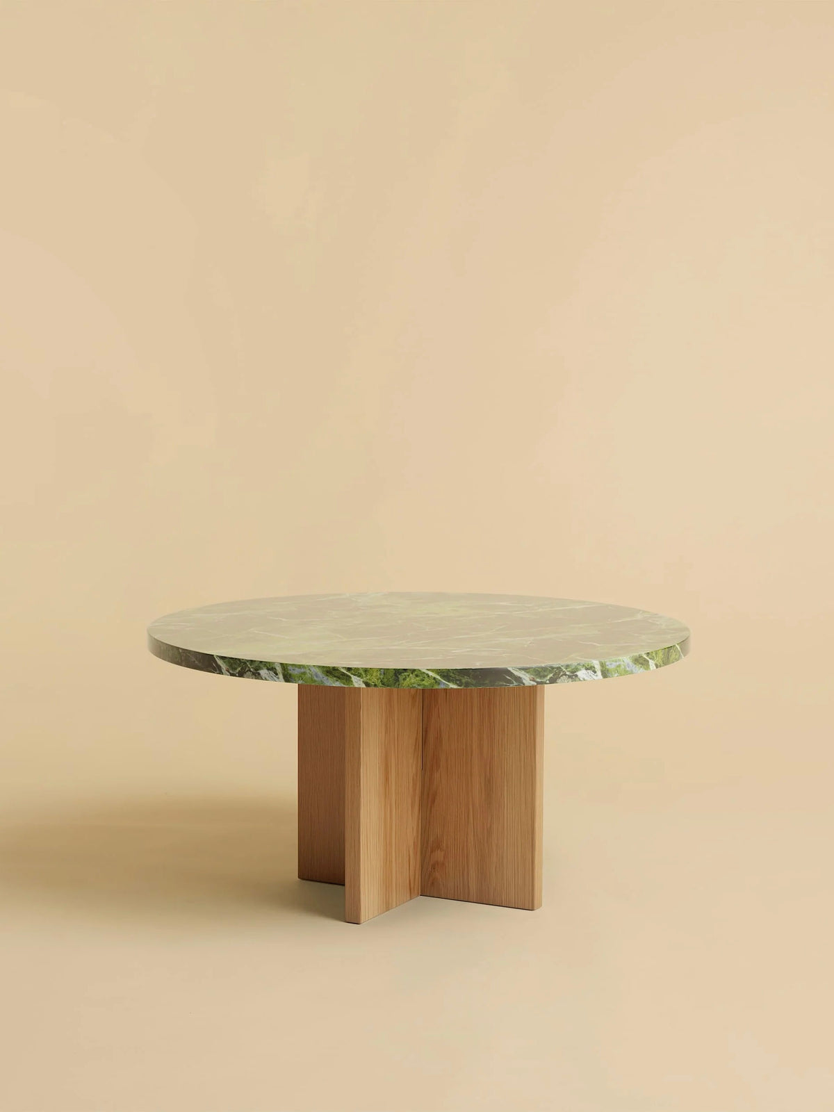 The Tinian Coffee Table by Lebanto features a green marble top with an oak wood base, expertly crafted and set against a beige backdrop.