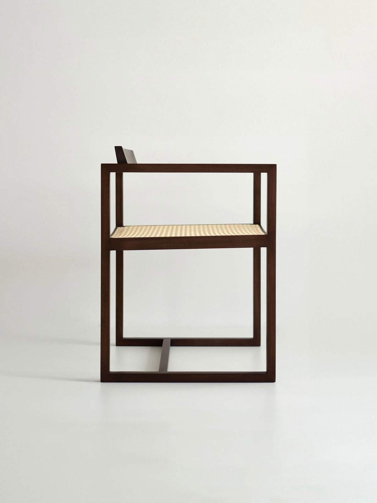 The "Amélia" Armchair by Andre Grippi features a modern, minimalist design with a dark wooden frame and a light woven straw seat, shown in profile against a plain white background.