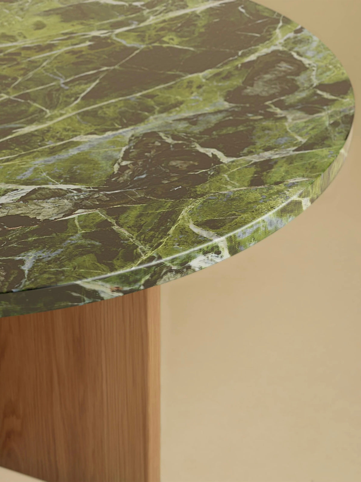Lebanto's "Tinian" Coffee Table combines a green marble top with white and dark veins on an oak base. This handcrafted piece contrasts a smooth stone surface against a neutral beige background.