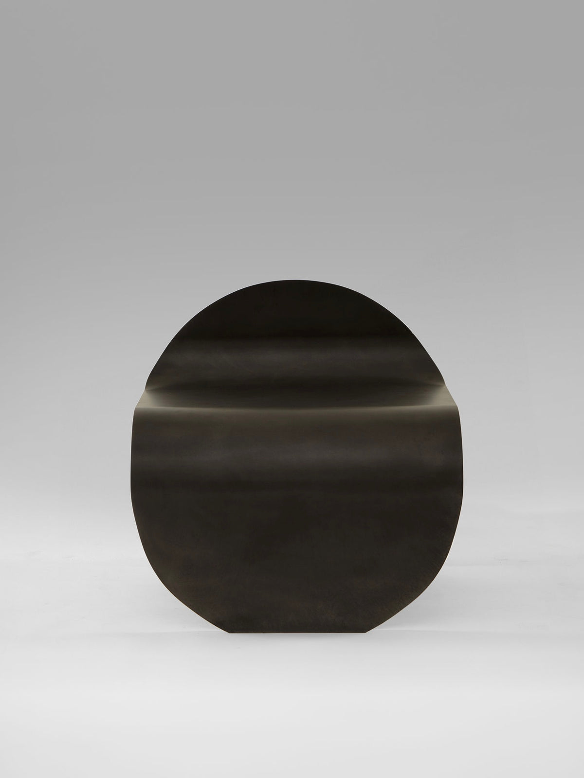 Dark wood O Stool by Estudio Persona with curved organic form