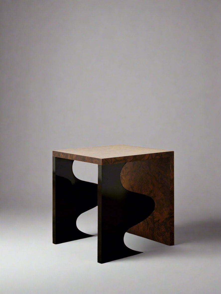 The Harlequin Side Table by Animate Objects features a brown wood-grain top and legs with black wavy cut-out sides, shown on a light gray background—a unique accent to enhance any space.