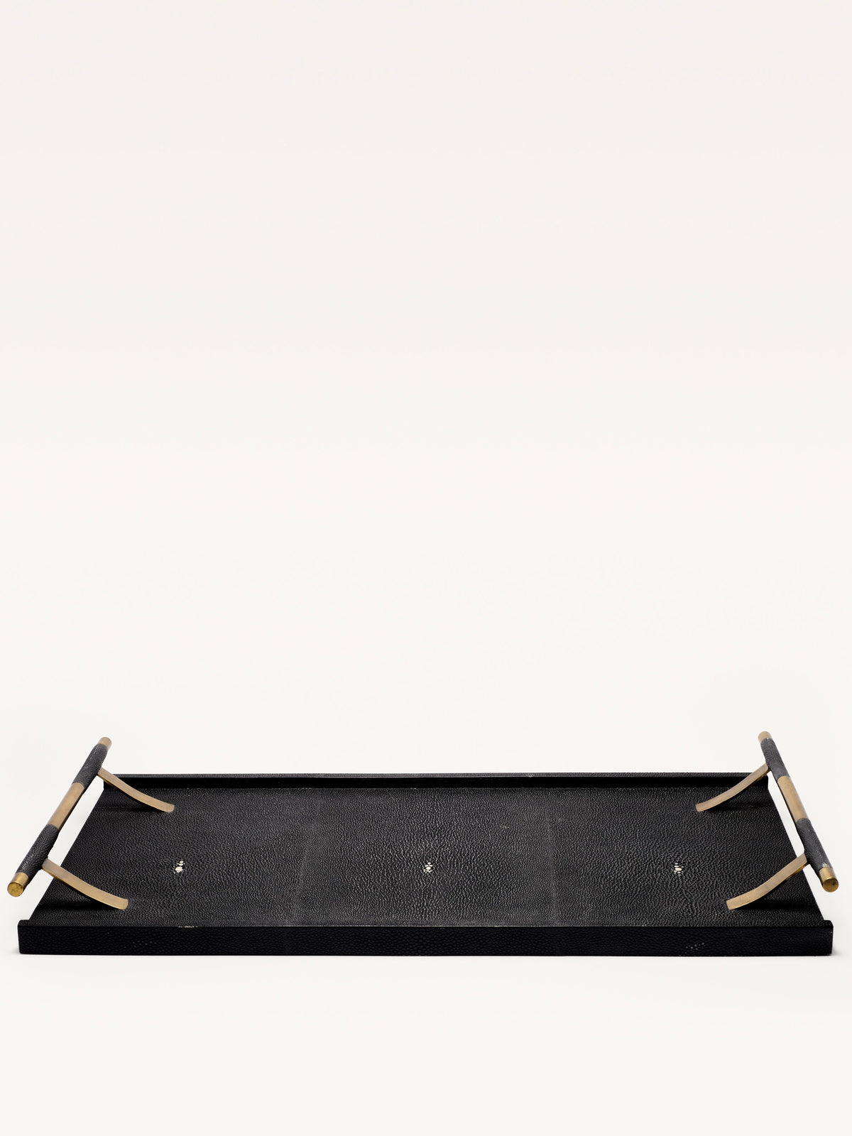 A rectangular Black Shagreen Tray by Galerie MLS, featuring a textured surface and tan foldable handles, is displayed upside down against a plain white background.