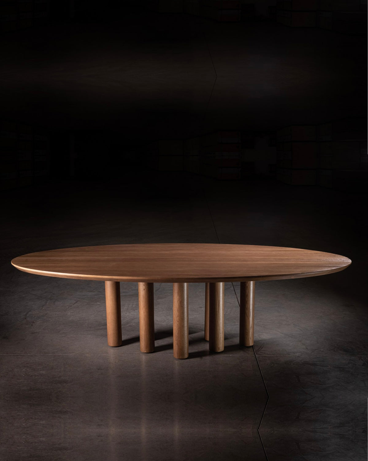 Oval walnut dining table with cylindrical wooden legs by No Age Studio