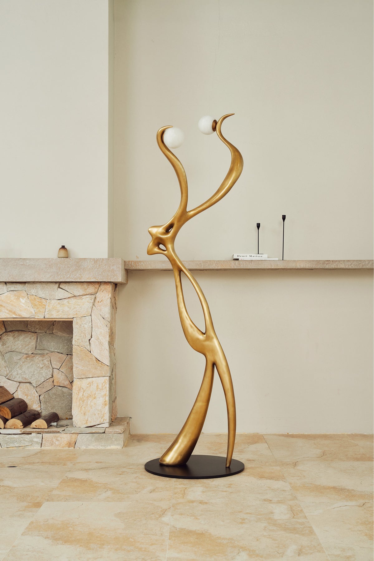 Sculptural gold floor lamp with dual globe lights, lifestyle view
