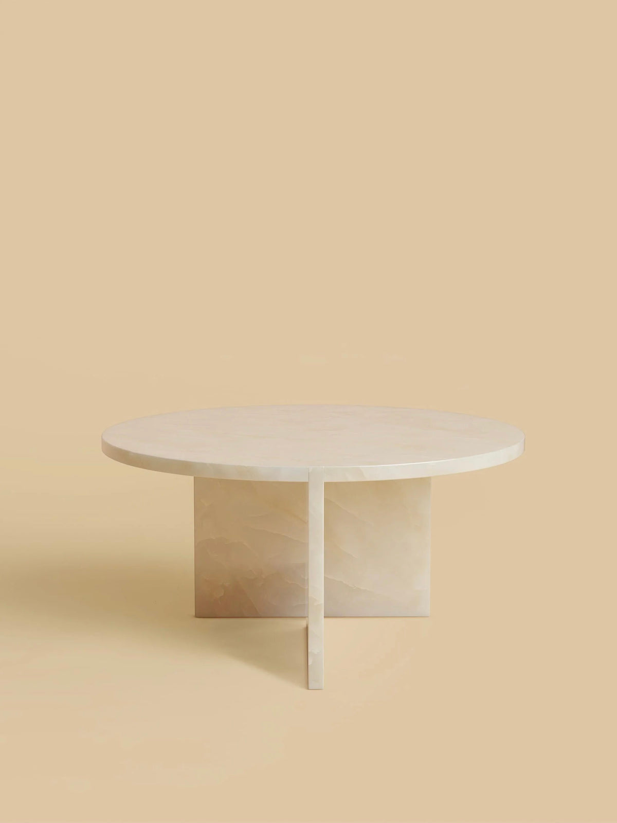 The "Hashi" Coffee Table by Lebanto, with a light beige finish and a distinct T-shaped base, exudes minimalist elegance against a matching backdrop.
