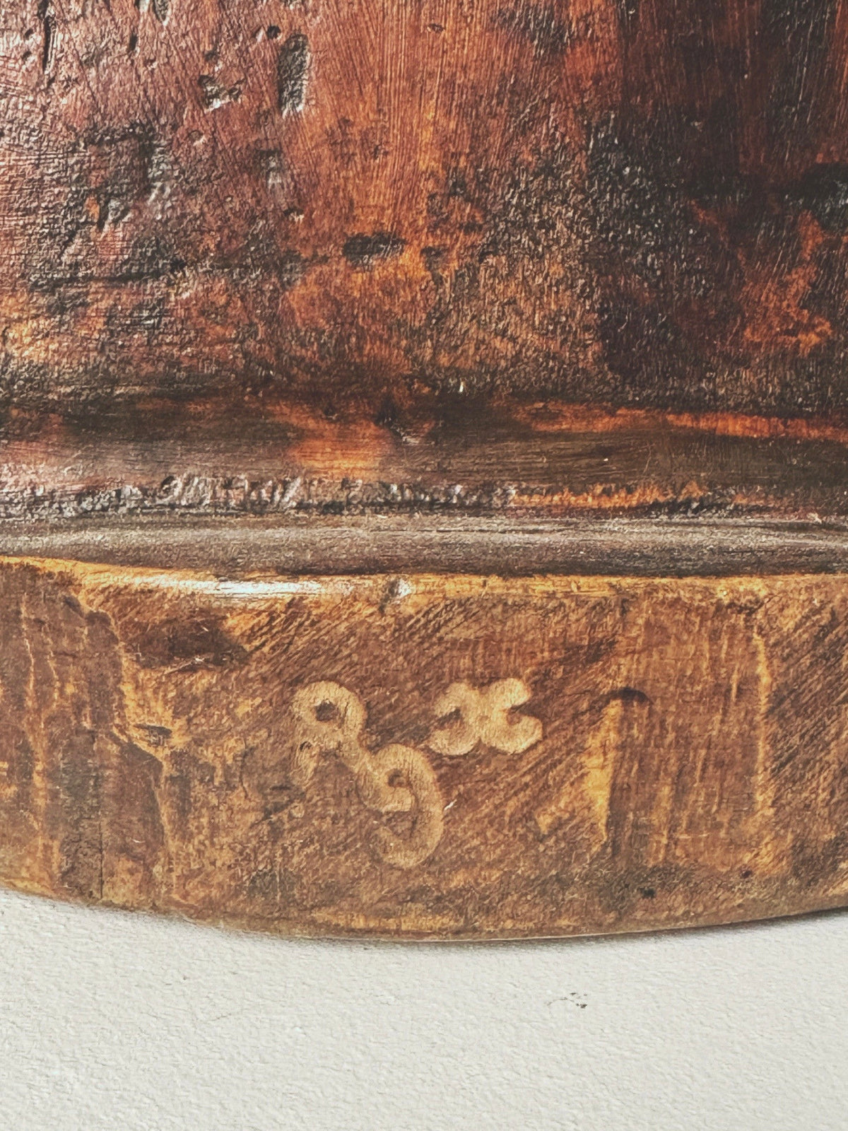 Close-up of the Large Anthropomorphic Wood Sculpture by Figuresdesign, showing etched markings—a backward "9" beside a lowercase "x" and "1" below—on reddish-brown and tan textured wood.