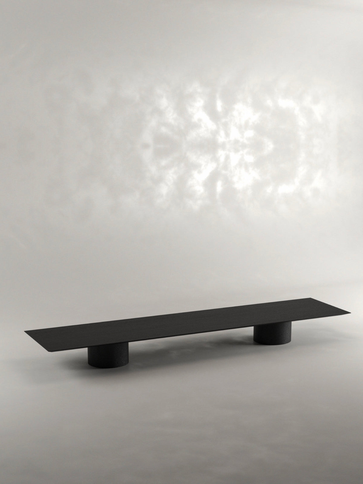 The 'Pier' Coffee Table by Siete Studio is a sleek, minimalist piece handcrafted from black oak with a flat, rectangular surface and two cylindrical legs, set elegantly against a neutral background.