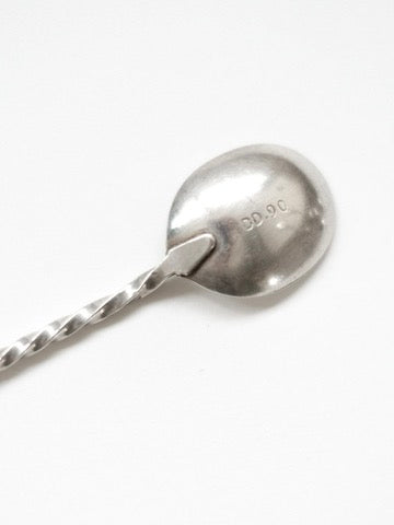 Close-up of silver-plated spoon bowl showing twisted handle detail