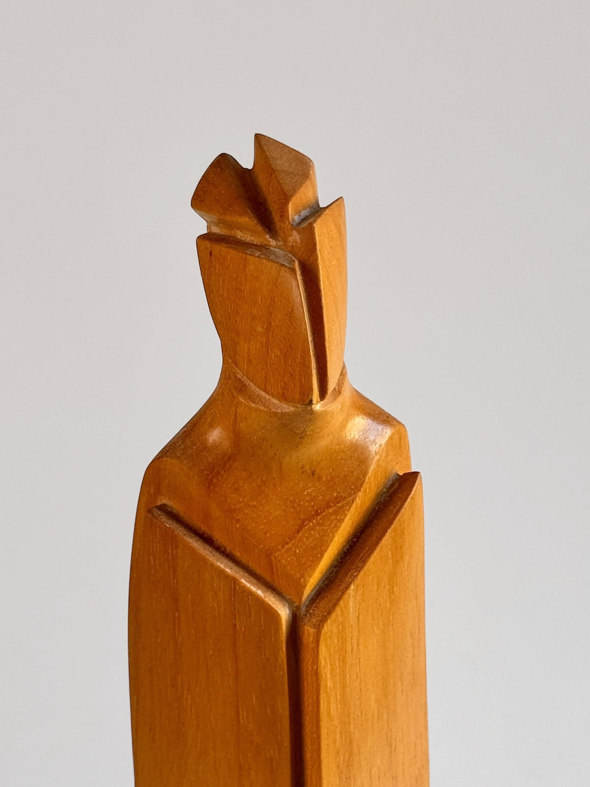 This one-of-a-kind piece by Pierre Dedieu, from Figuresdesign, is titled "Light Wood Sculpture" and showcases an abstract human form with angular, geometric lines and a helmet-like head. The sculpture's smooth, polished light wood texture accentuates the natural grain against a neutral background.