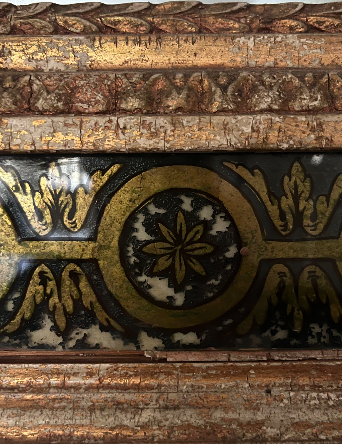 Close-up of a Médecine Antique Gilded Mirror’s ornate giltwood frame, featuring gold and black leaf and floral patterns with graceful aged wear.