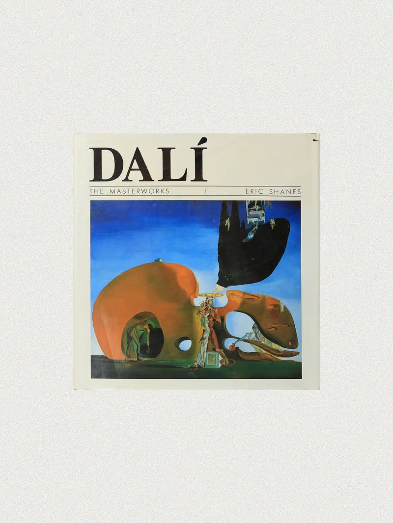 The cover of "Dali The Masterworks Book" from Boga Avante Shop features a captivating Salvador Dalí painting with surreal elements against a blue sky, highlighting his genius as a surrealist painter with the prominent DALÍ title at the top.