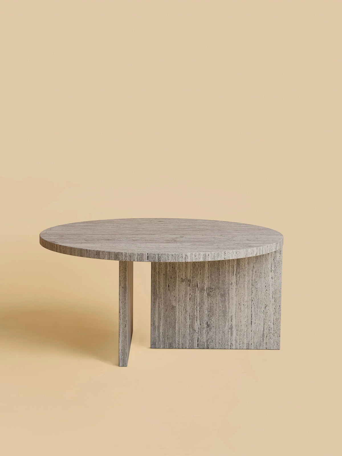 The "Hashi" Coffee Table by Lebanto features a modern, round design with a unique asymmetric base. It resembles an elegant circular table set against a plain beige background, with a smooth tabletop and an intersecting two-slab base.