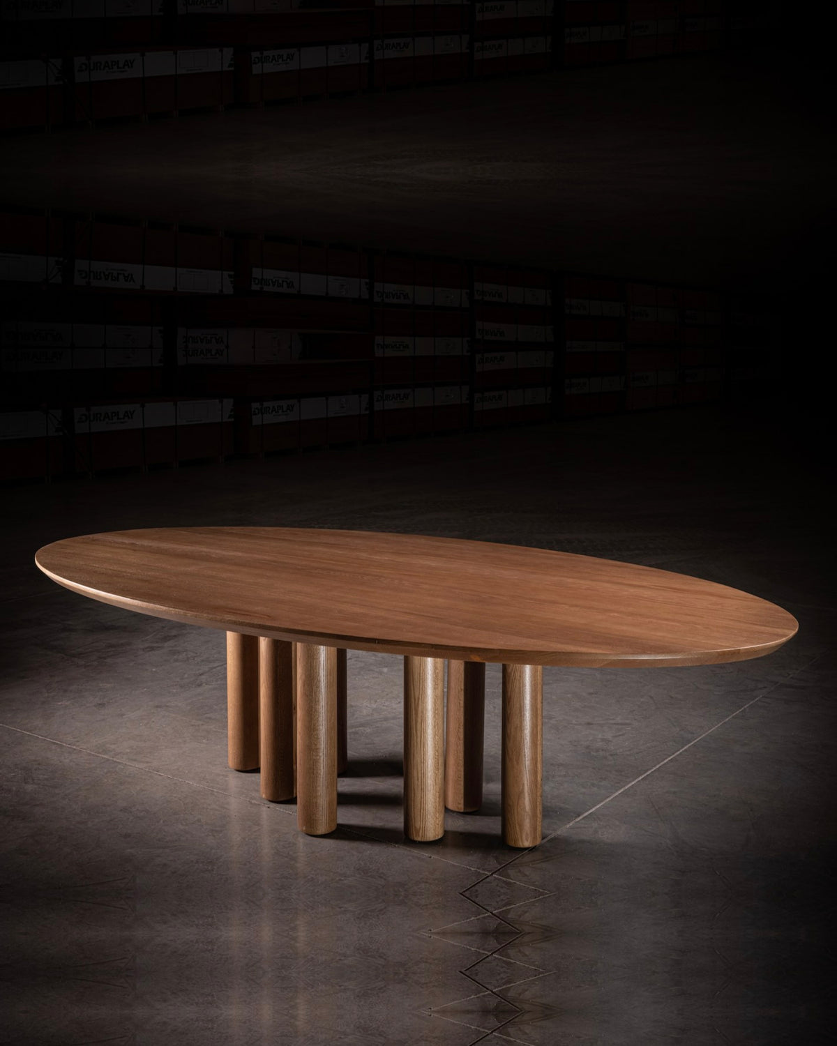 Modern oval walnut dining table with cylindrical legs by No Age Studio