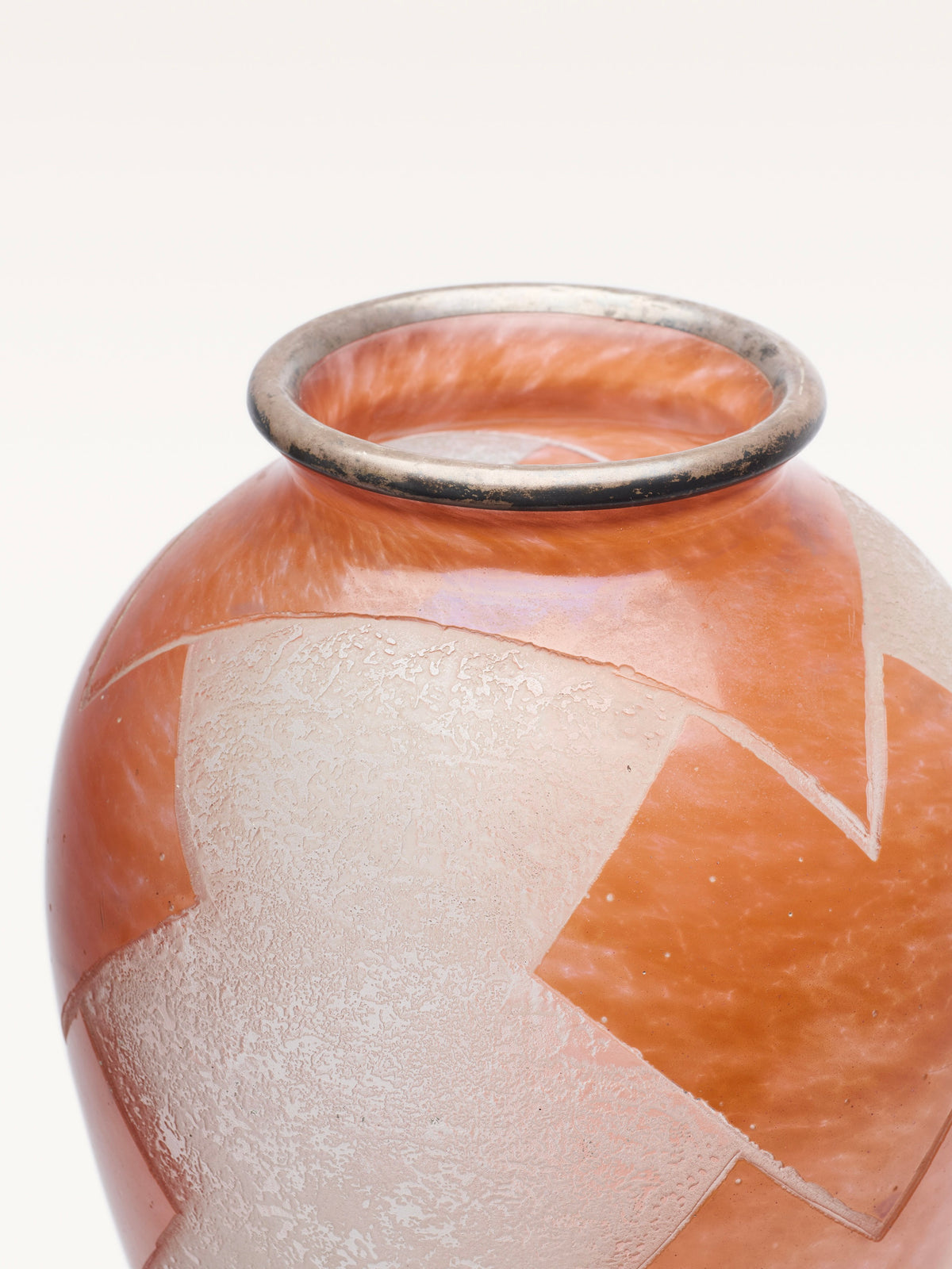 A close-up of the Galerie MLS Glass Baluster Object, inspired by 1930s Art Deco style in orange, showcasing sandblasted geometric shapes and a metallic rim, set against a white background.