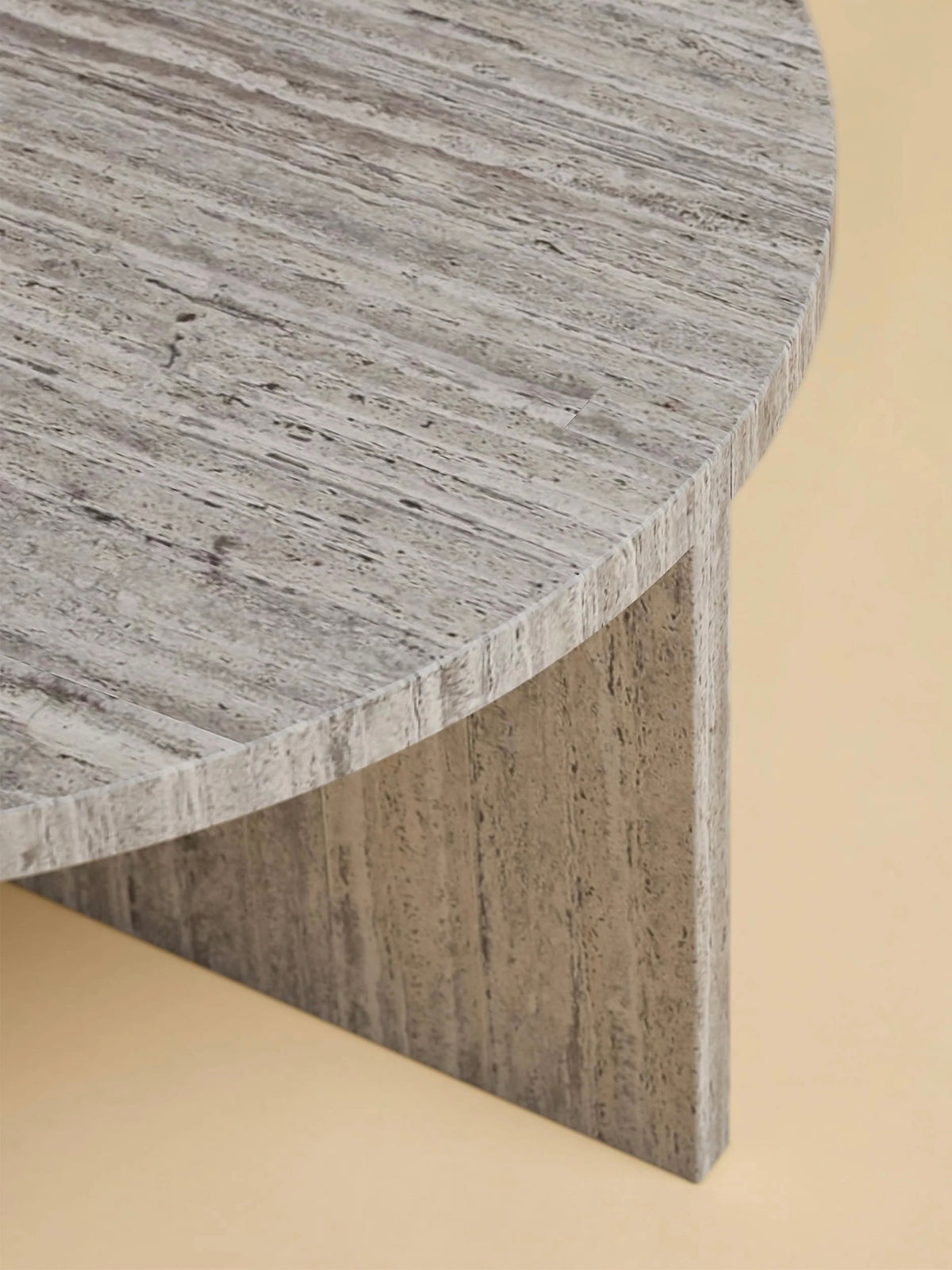 A close-up of the Lebanto "Hashi" Coffee Table in Marble reveals its textured gray marble surface and matching vertical support against a soft beige background, showcasing natural streaks and tonal variations.