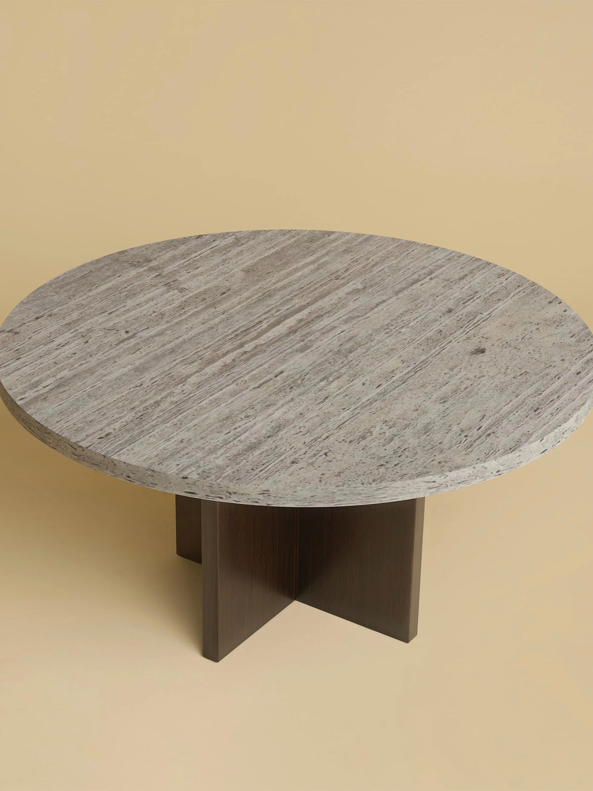 The "Tinian" Coffee Table by Lebanto boasts a round grey marble top with a textured surface on an oak wood base, showcased against a beige background.
