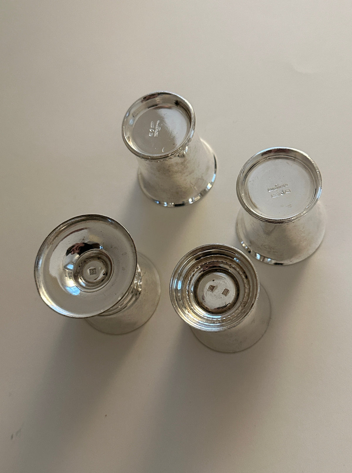 Four elegant egg cups with shiny silver finish and stylish design