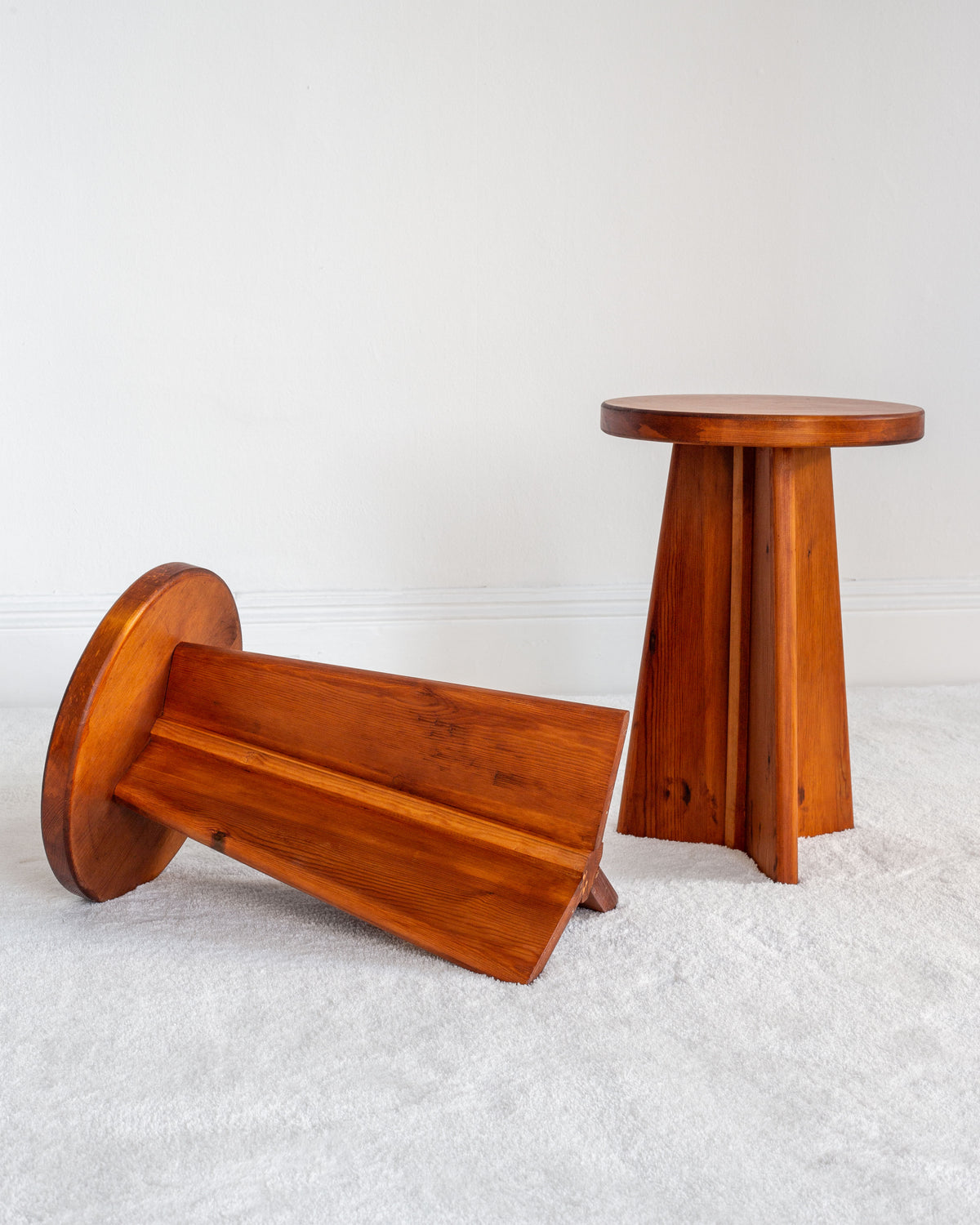 Vintage Swedish pine stools showing one upright, one tipped over