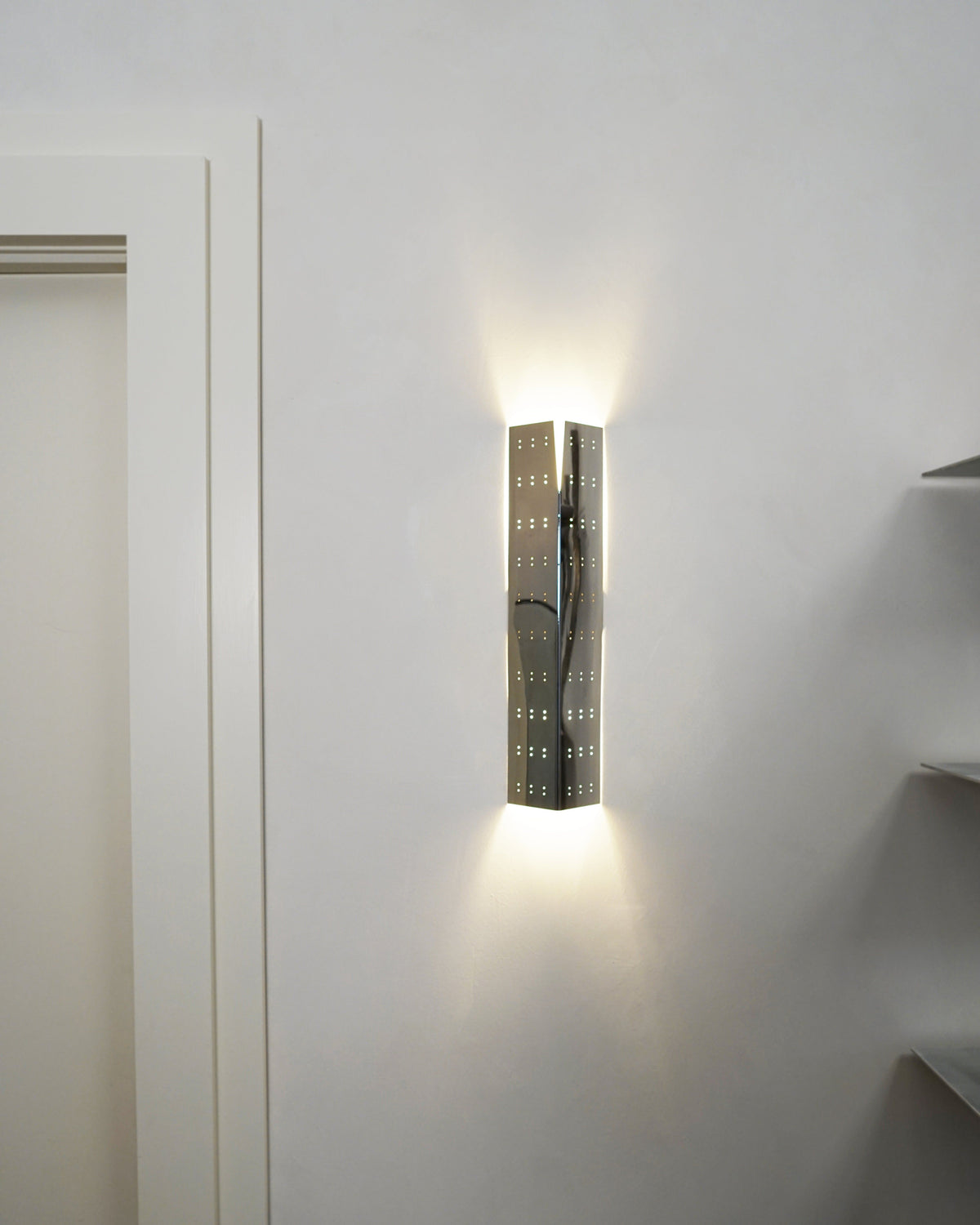 May Wall Lamp - Polished Steel — close-up of wall-mounted light fixture