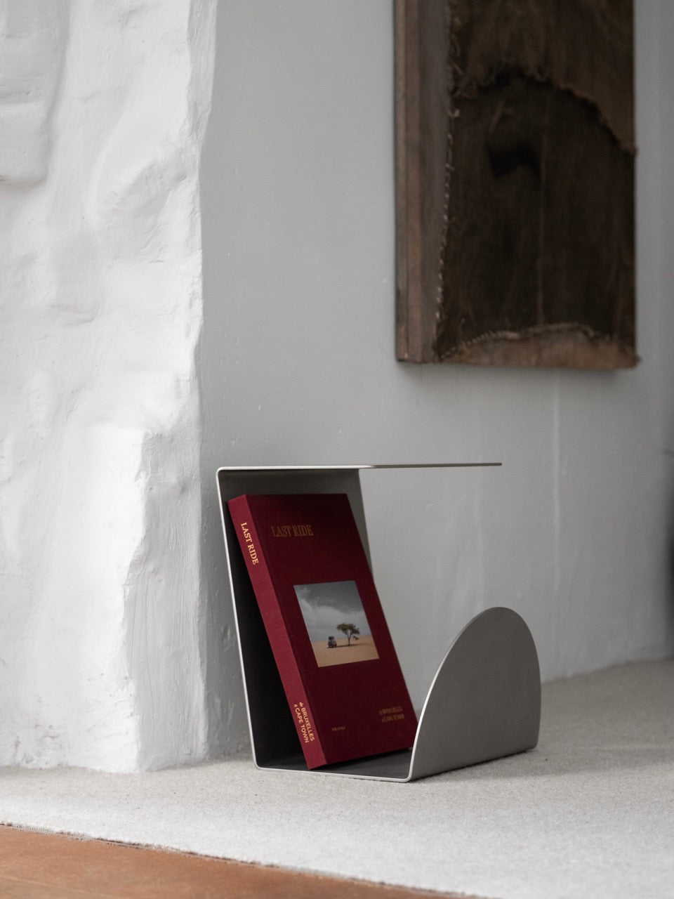 Side Table - 1.0 - Stainless Steel — side angle with book on table