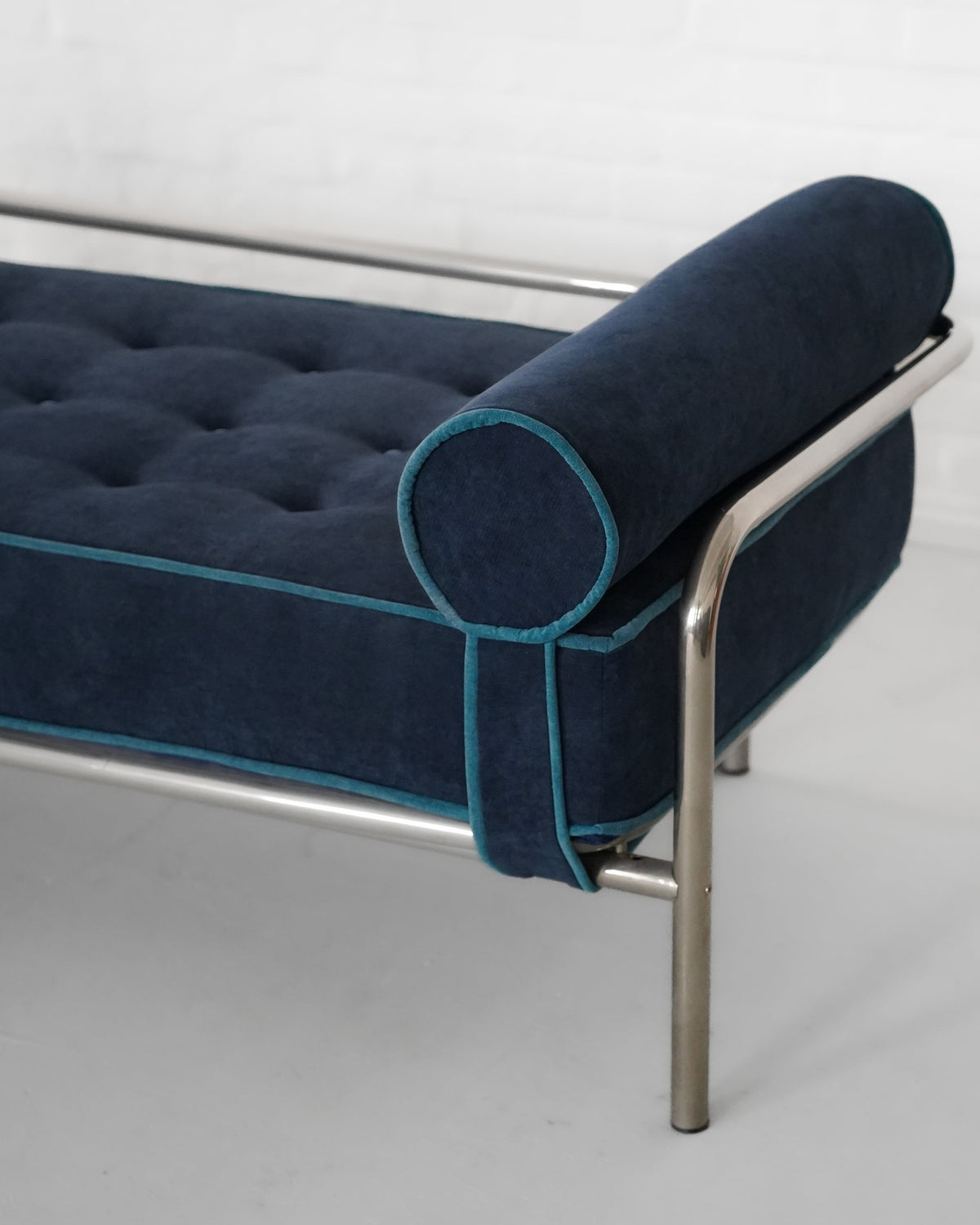 Close-up detail of navy velvet upholstery with teal piping on Locus Solus daybed