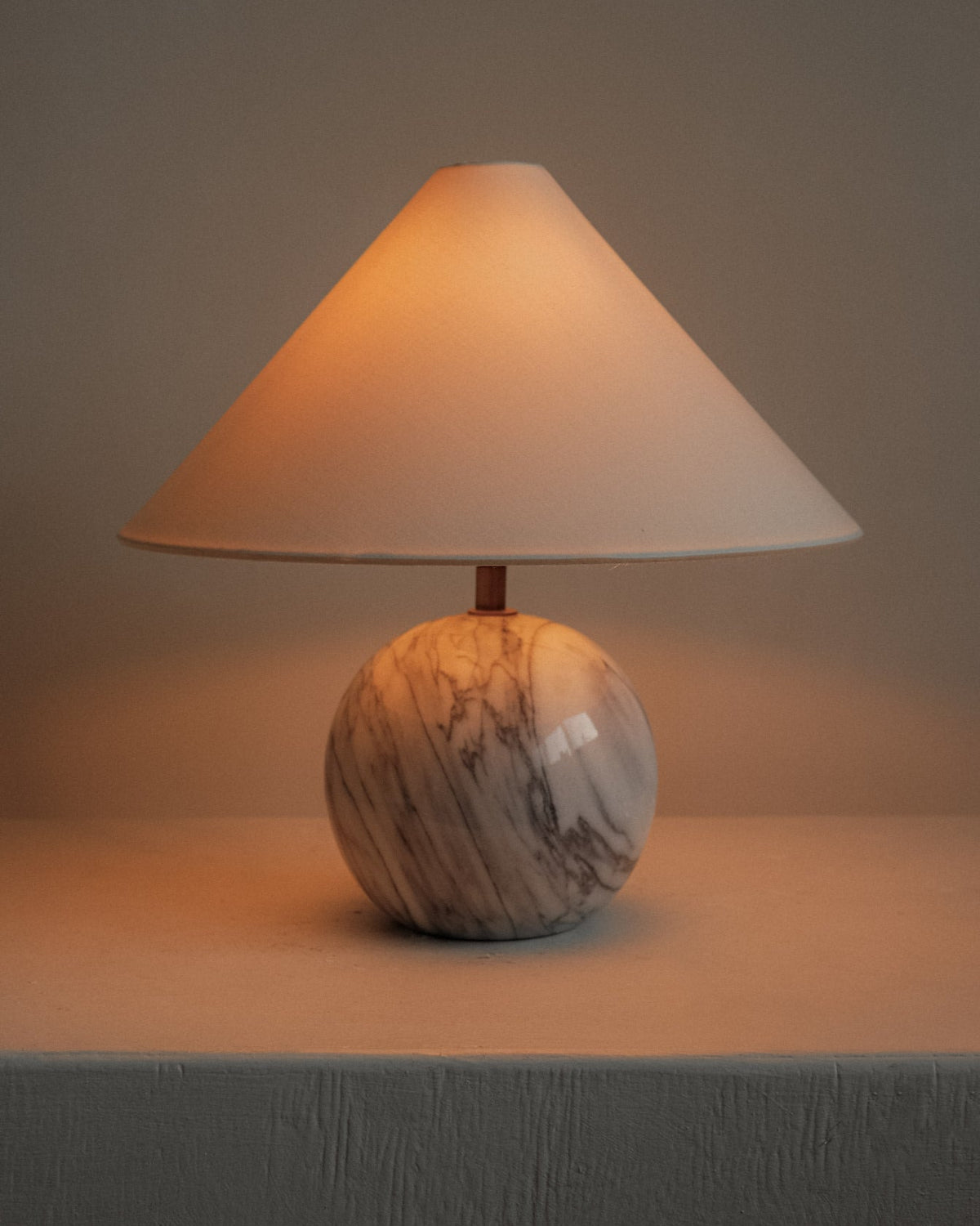 Marble Table Lamp — side angle with warm light on marble base