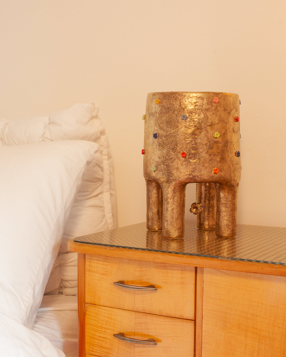Gold ceramic table lamp with colorful glass dots on nightstand