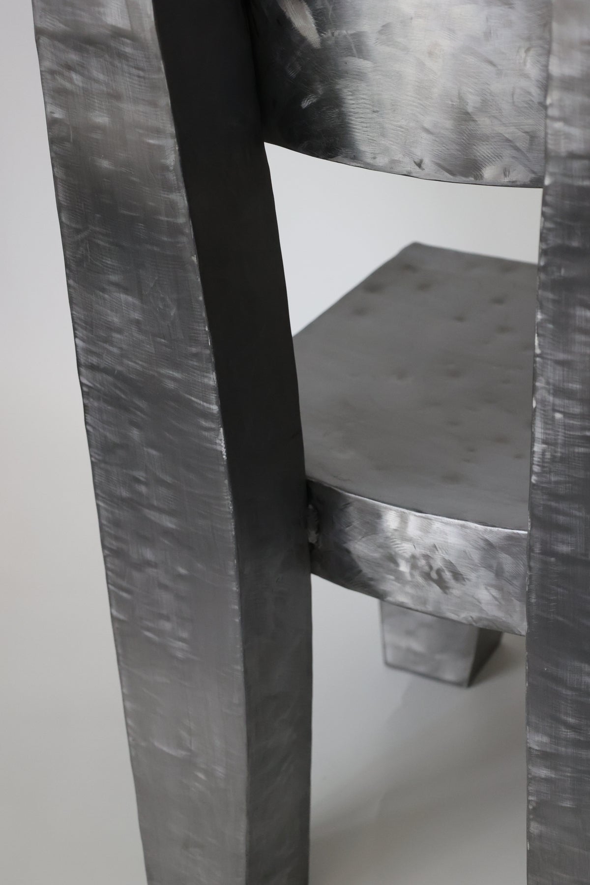 Close-up detail of Joe chair's brushed metal leg construction