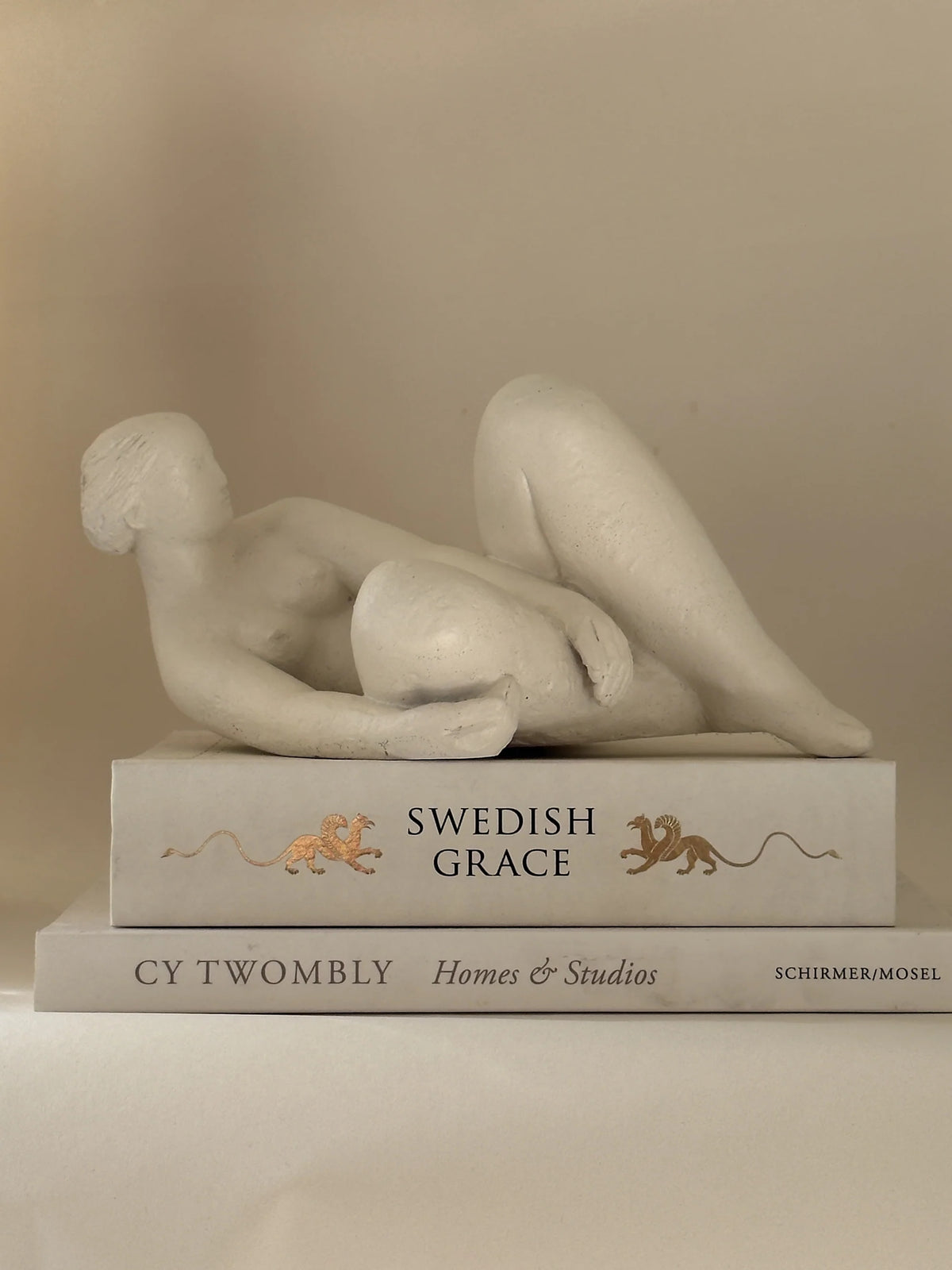 Reclining Female Figure Sculpture, Jan Keustermans — detail on stacked art books