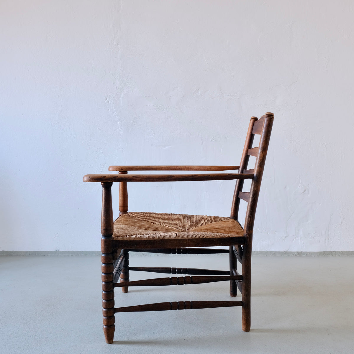 Rustic Bobbin Rush Seat Low Armchair | Netherlands | 1940s — lifestyle setting