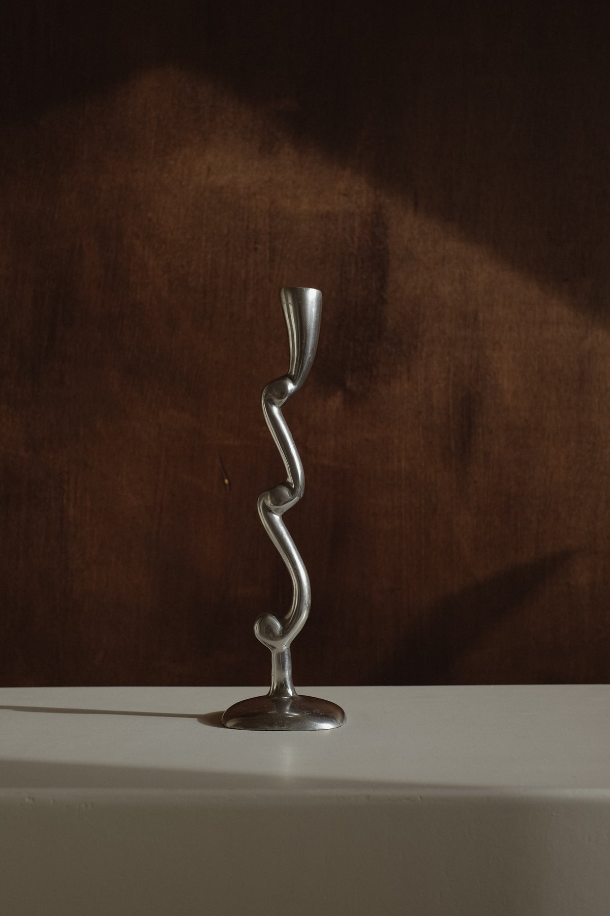 Curly Candle Holder — close-up of twisted metal design on white surface