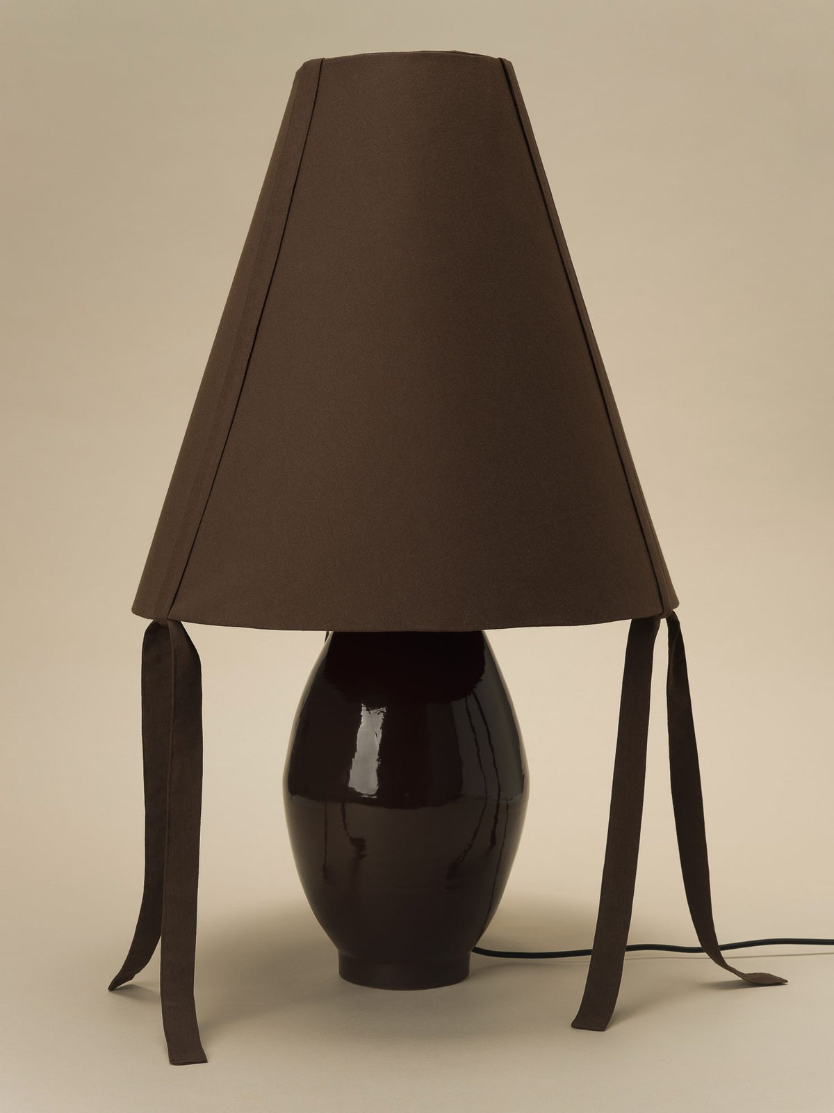 Brown ceramic table lamp with dark fabric shade and ribbon ties, Los Objetos Decorativos