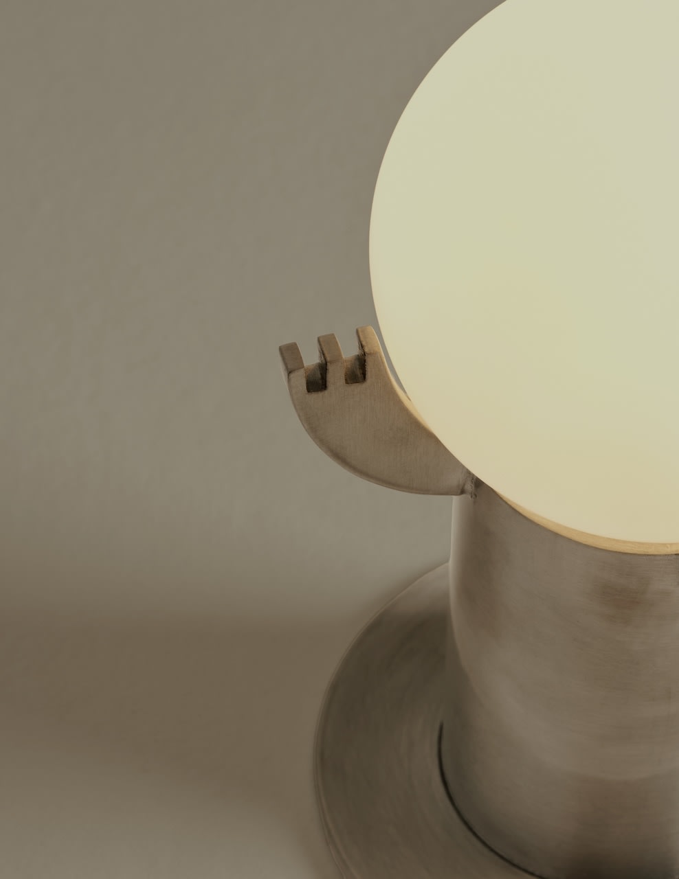 Mago table lamp detail showing curved wooden base and glowing sphere