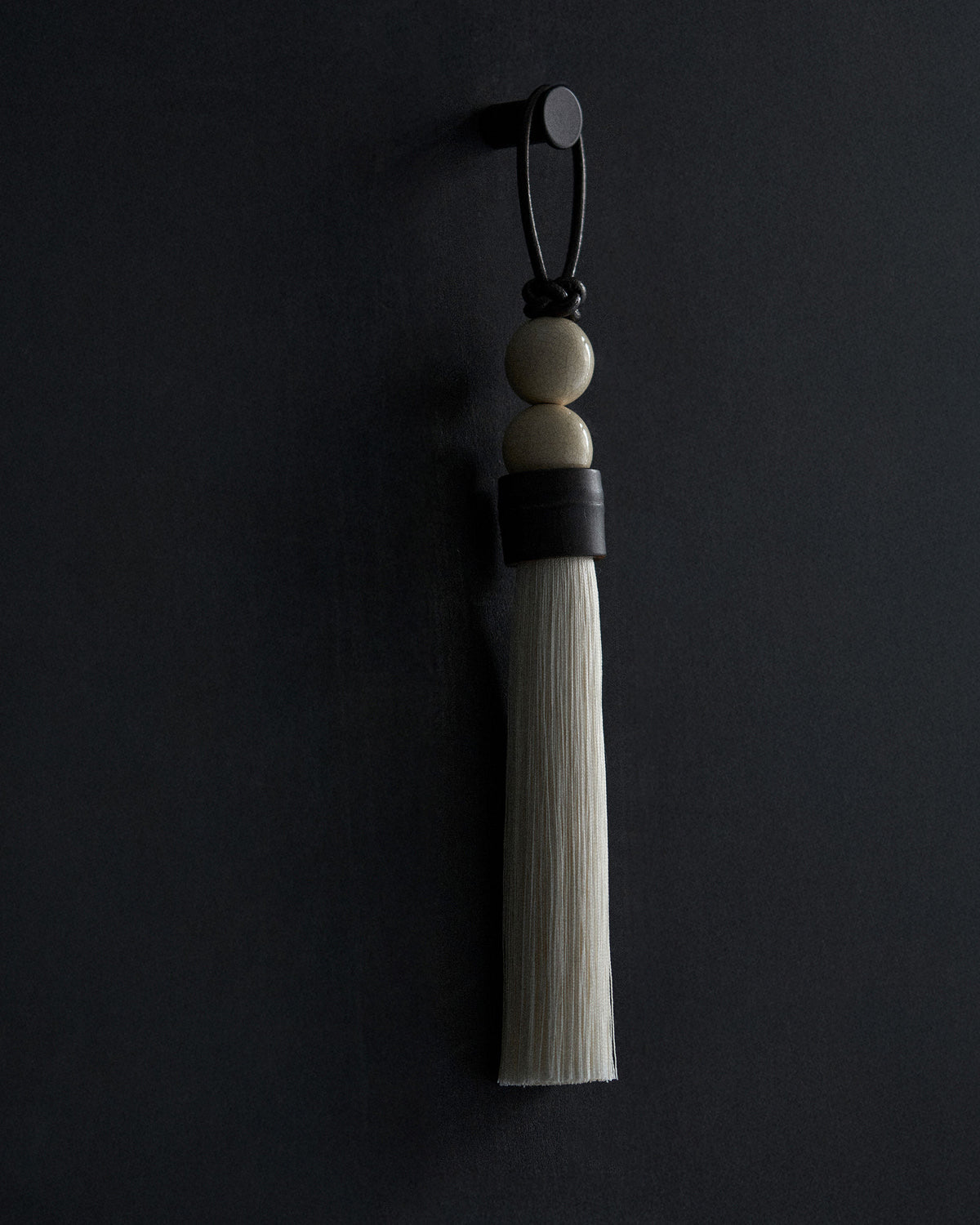 Elegant white tassel ornament with wooden beads and leather strap