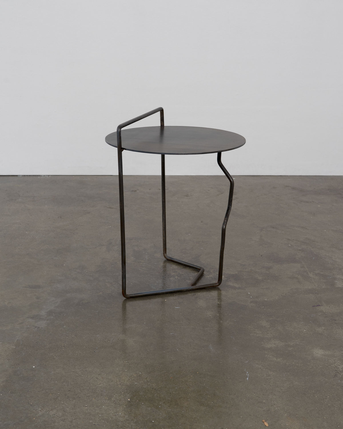 Sculptural Patinated Steel Side Table — close-up of round top and base