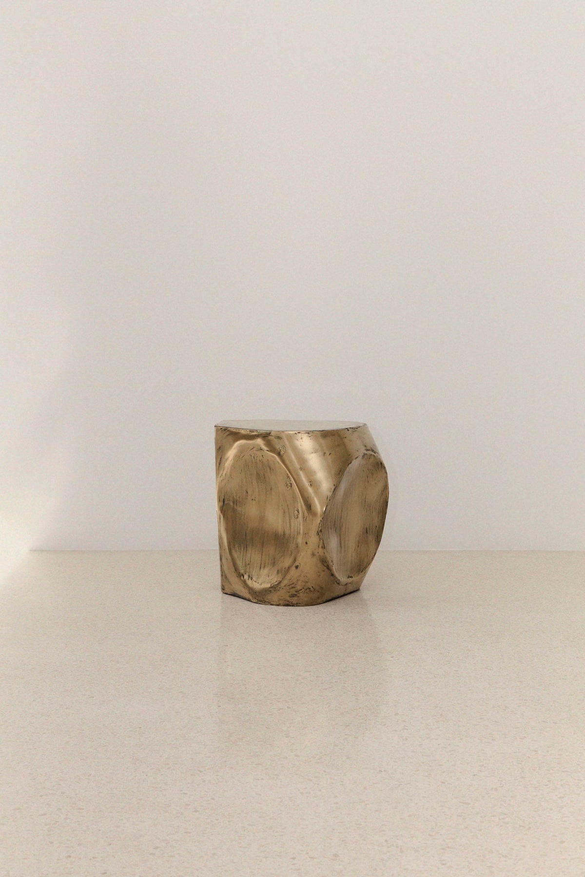 ROCHER SMALL TABLE IN POLISHED BRASS RESIN — angled view highlighting textured brass finish