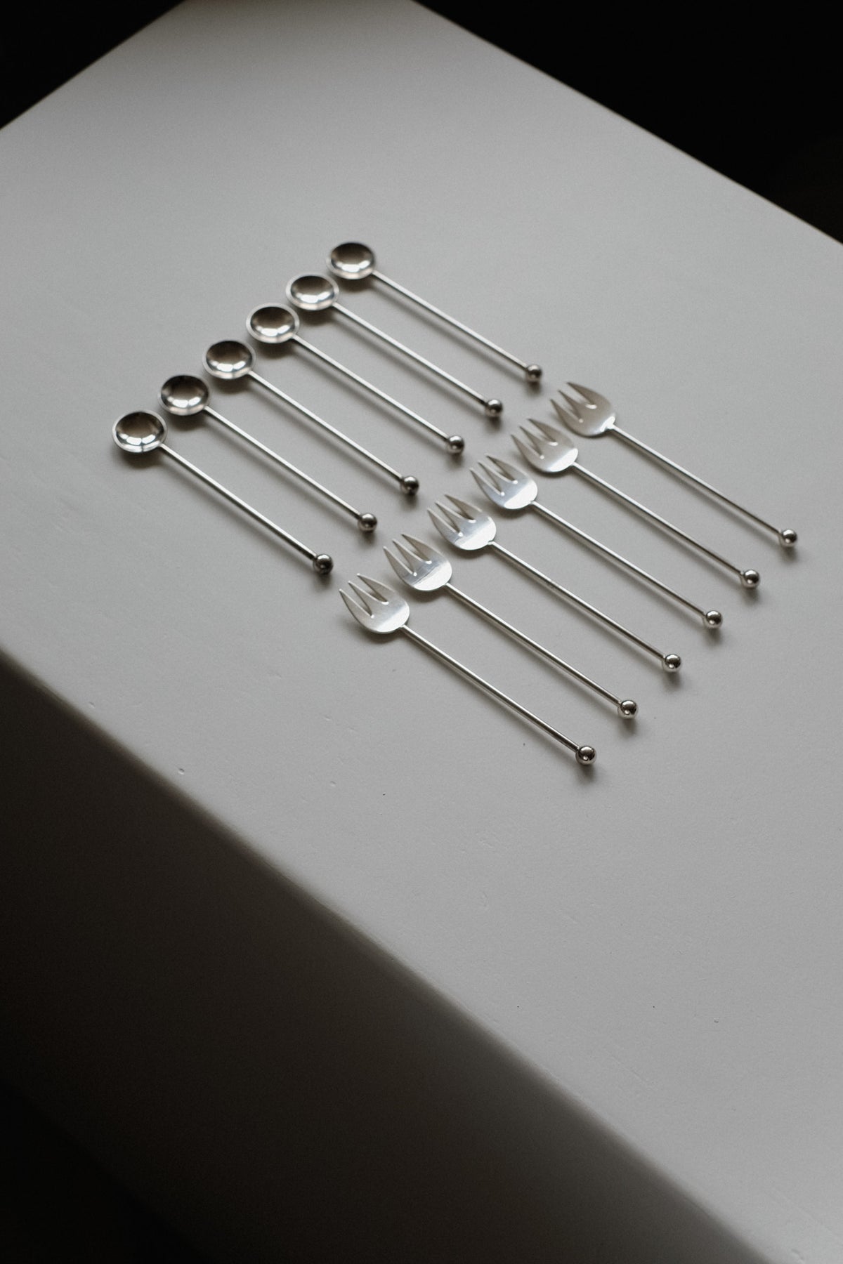 Silver-Plated Cutlery Set — top view of arranged utensils on white surface