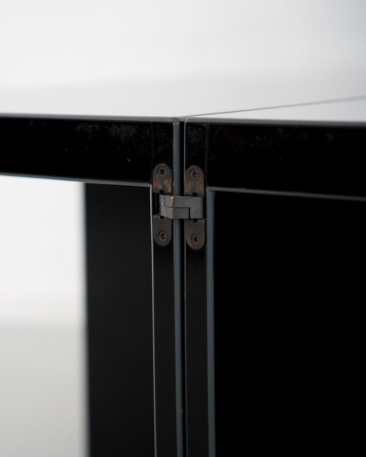 Detail of concealed hinge mechanism on black Domino side table