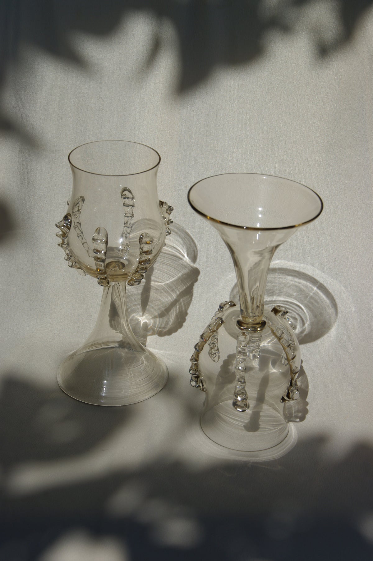 Pair of mouthblown glass wine goblets with decorative ribbed stems