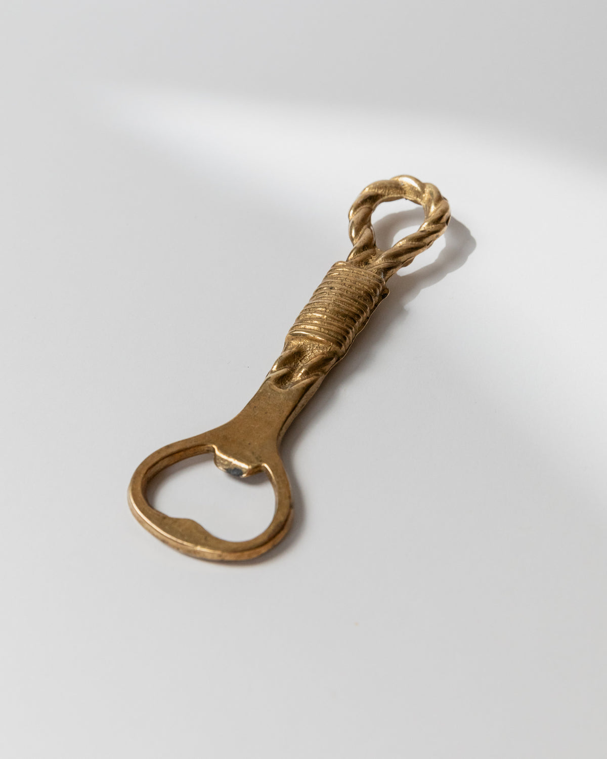 Vintage brass bottle opener with twisted rope handle detail